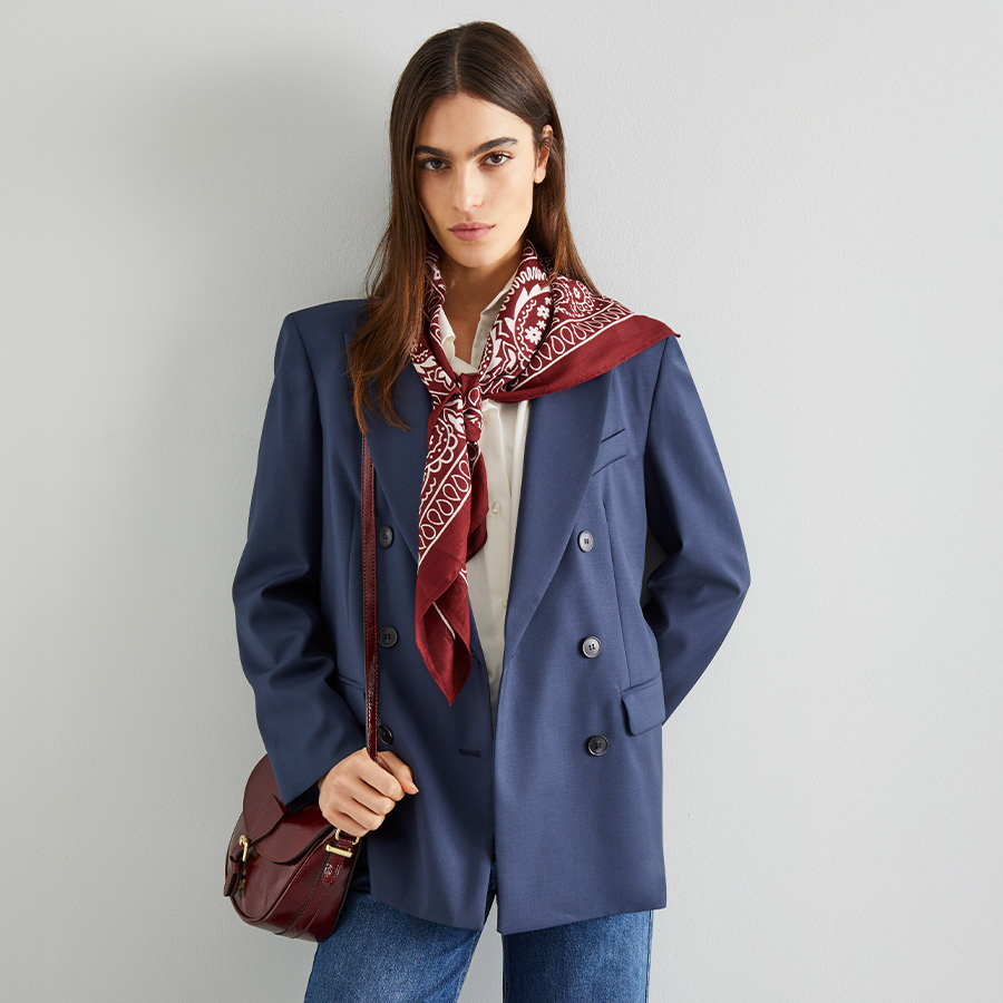 Modella indossa blazer blu con foulard bordeaux.